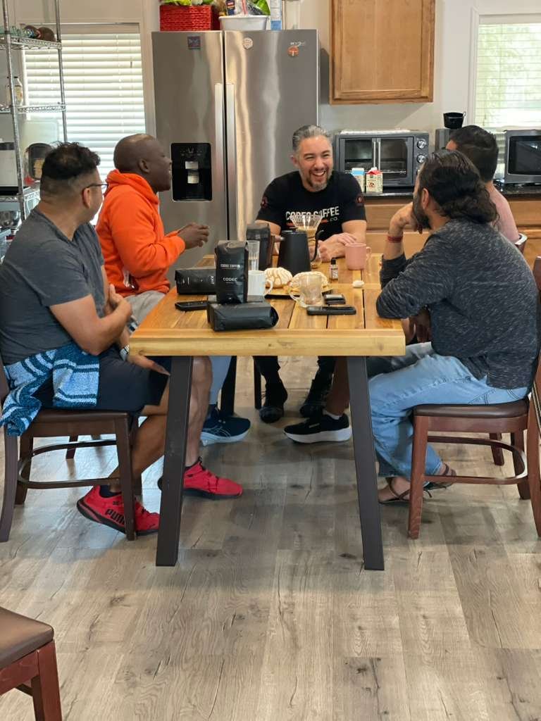 Community members gathered around a table in conversation
